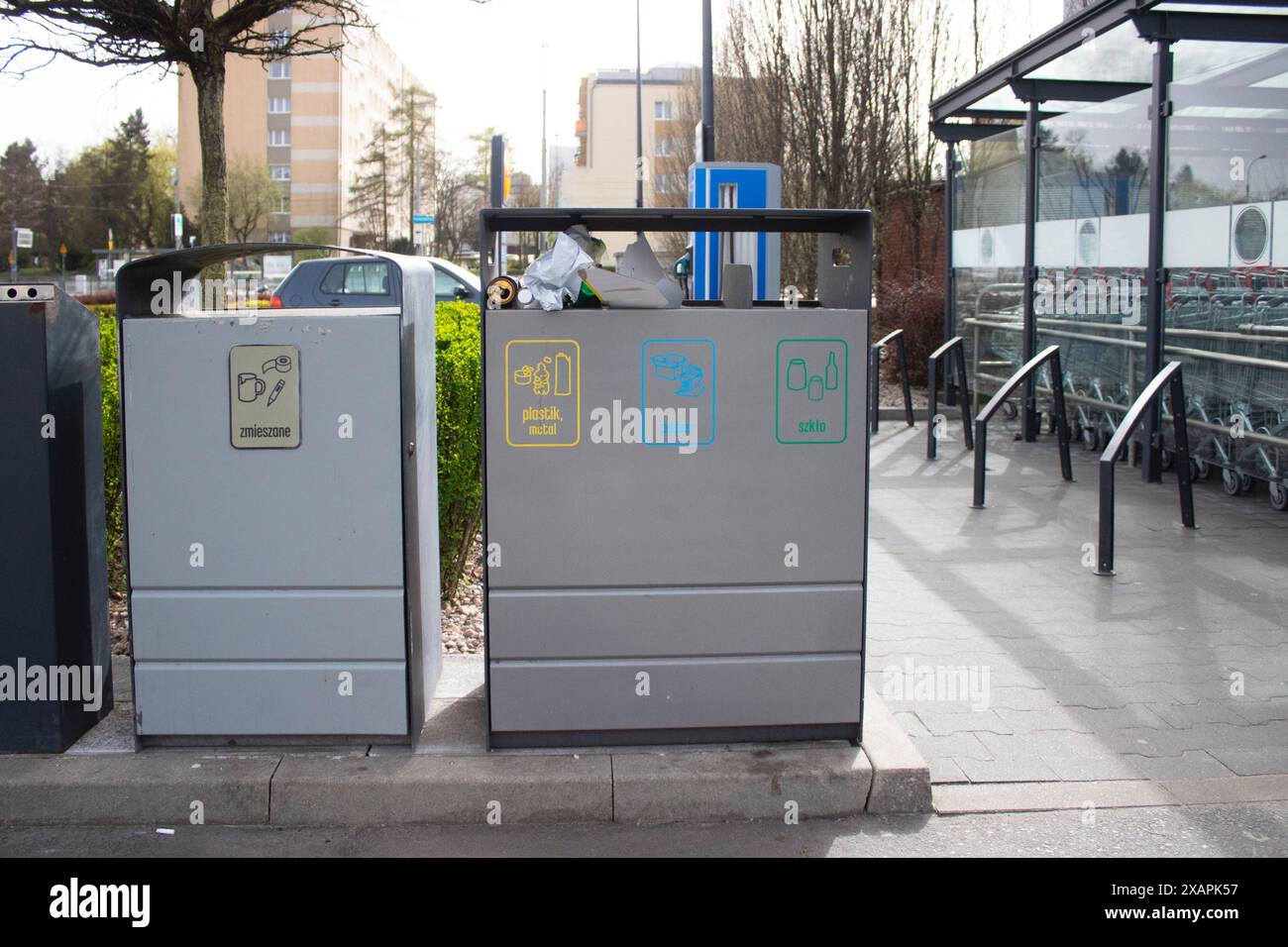 Public garbage bin with waste separation on a city street filled with garbage Stock Photo