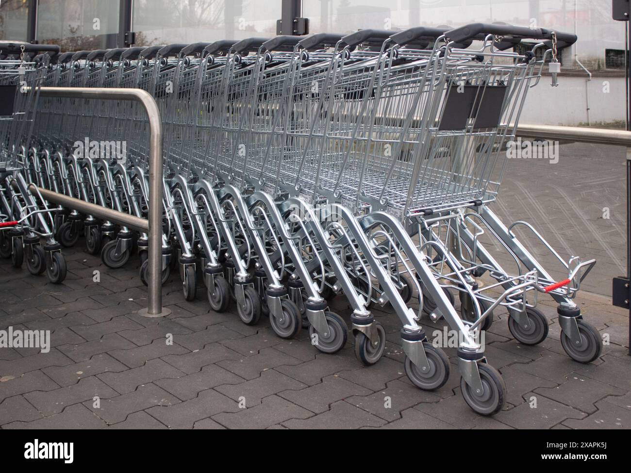 Metal grocery carts stand in a store parking bay Stock Photo