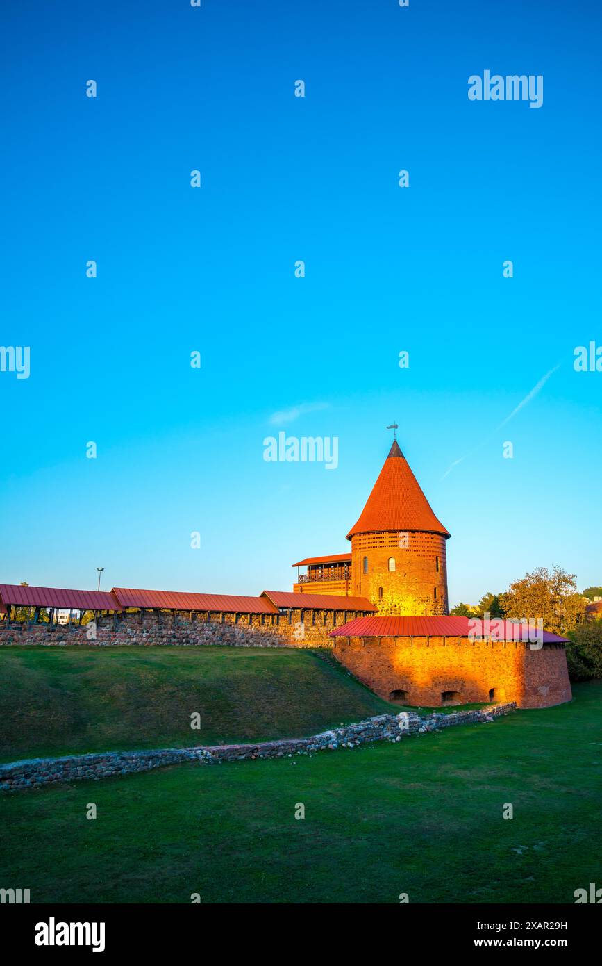 Kaunas, Lithuania, September 28, 2023, Old historic red brick castle building in kaunas city in warm sunset light in summer with blue sky, famous tour Stock Photo