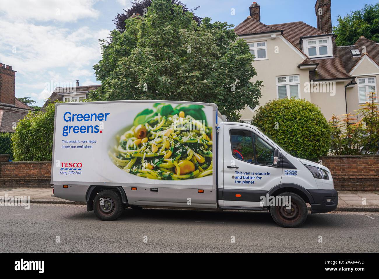 A Tesco electric grocery delivery van parked in a street in Wimbledon