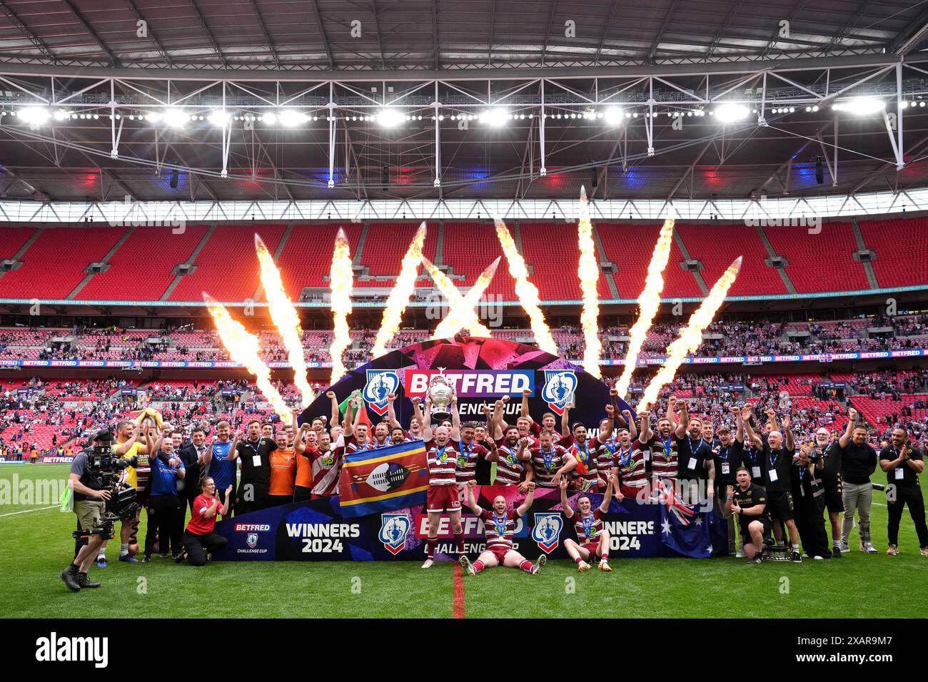 Wigan Warriors' Liam Farrell (centre) lifts the trophy with team-mates ...