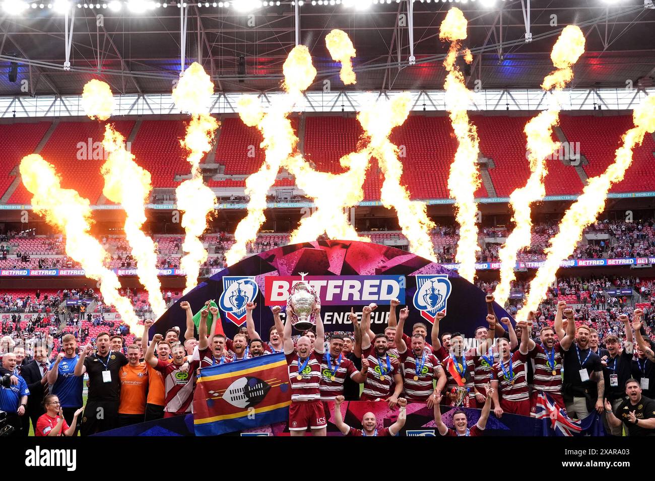 Wigan Warriors' Liam Farrell (centre) lifts the trophy with team-mates as pyrotechnics are set off after victory in the Betfred Challenge Cup final at Wembley Stadium, London. Picture date: Saturday June 8, 2024. Stock Photo