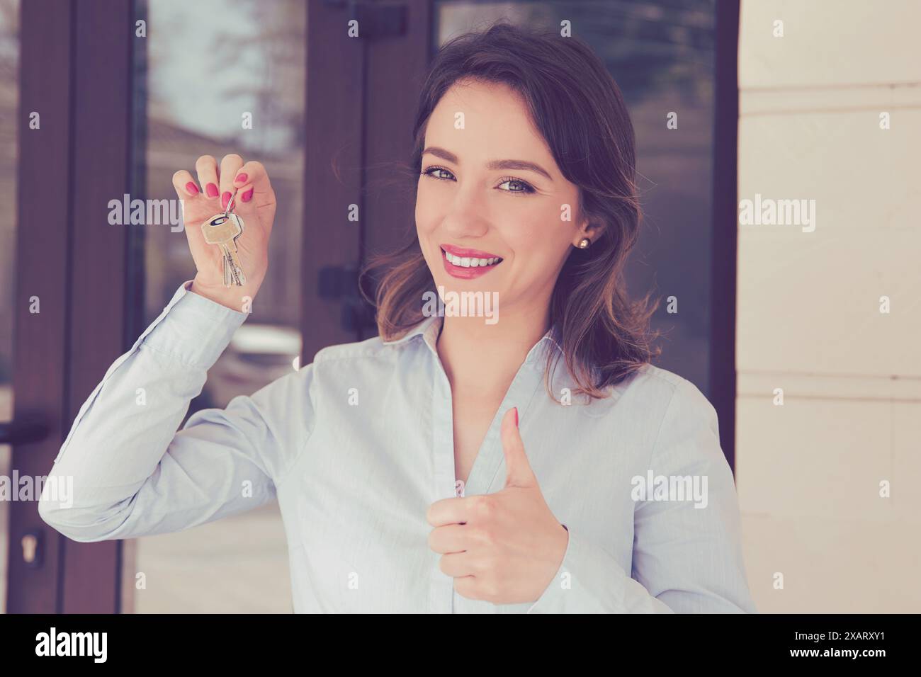Happy woman holding keys from new apartment and giving thumbs up Stock ...