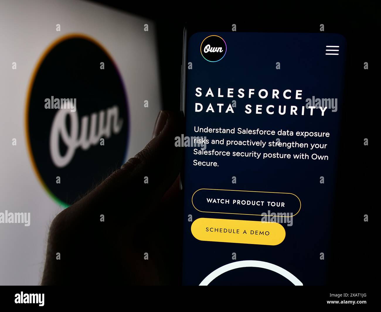 Person holding smartphone with webpage of US data platform business Own Company (OwnData) in front of logo. Focus on center of phone display. Stock Photo