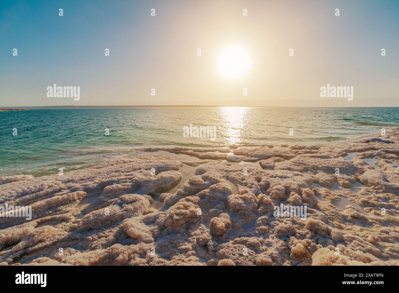 Breathtaking view of a serene sunset reflecting on the tranquil Jordanian waters of the Dead Sea in Jordan, with salt formations Stock Photo