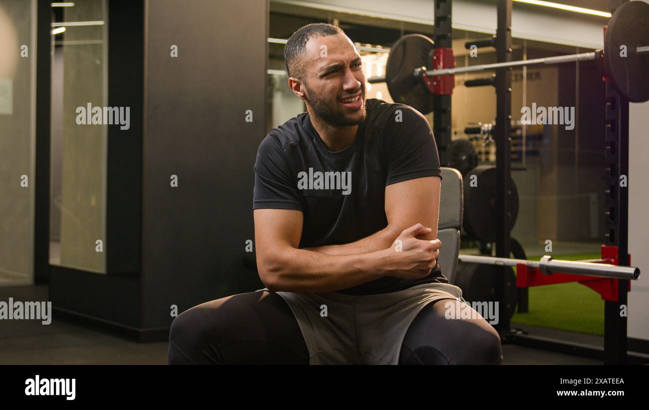 African American man guy in gym doing sport exercise with dumb-bell curl biceps workout sportsman athlete lifting up heavy dumbbell weights feel sharp Stock Photo