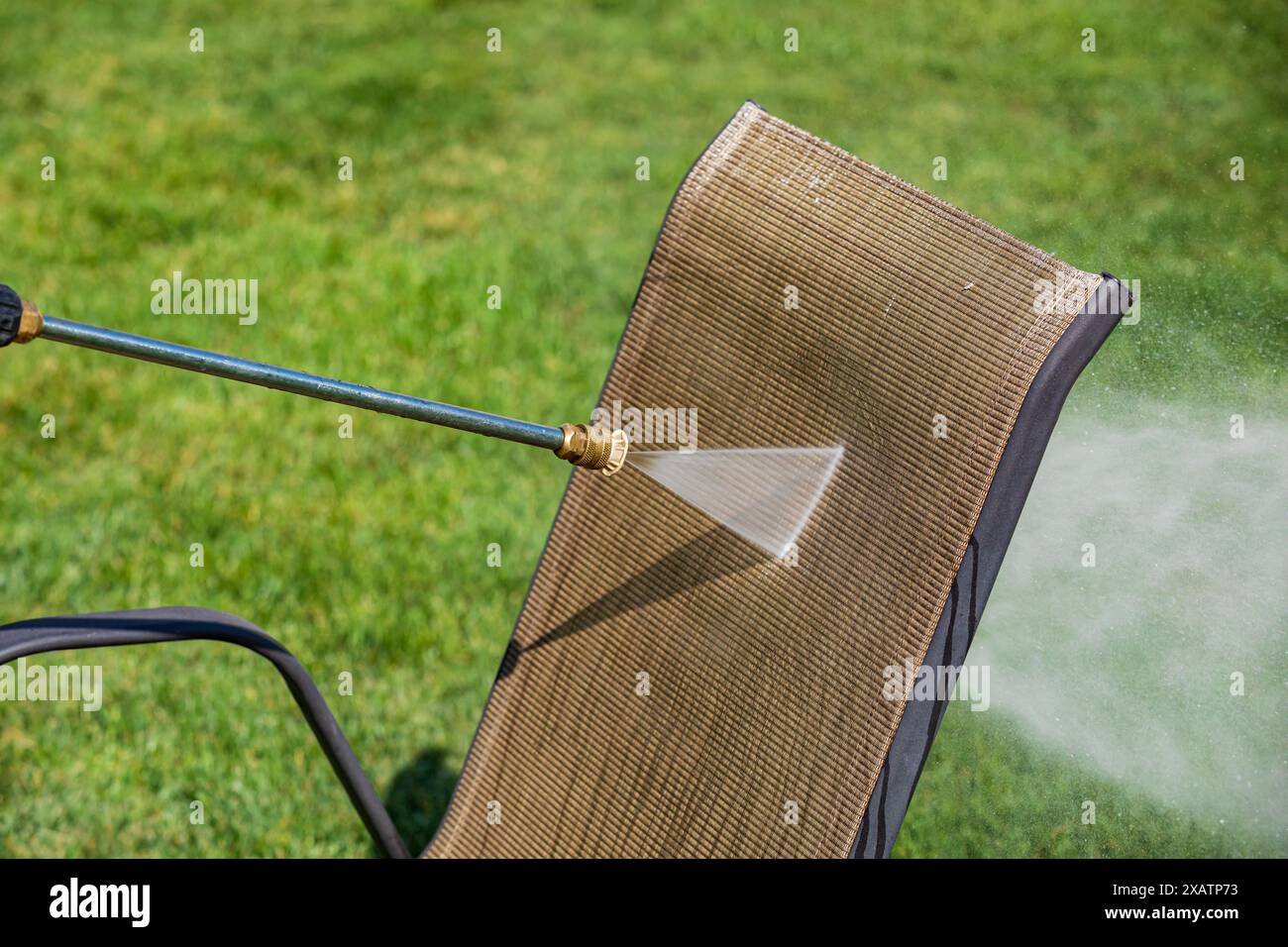 Cleaning patio furniture with pressure washer. Spring cleaning