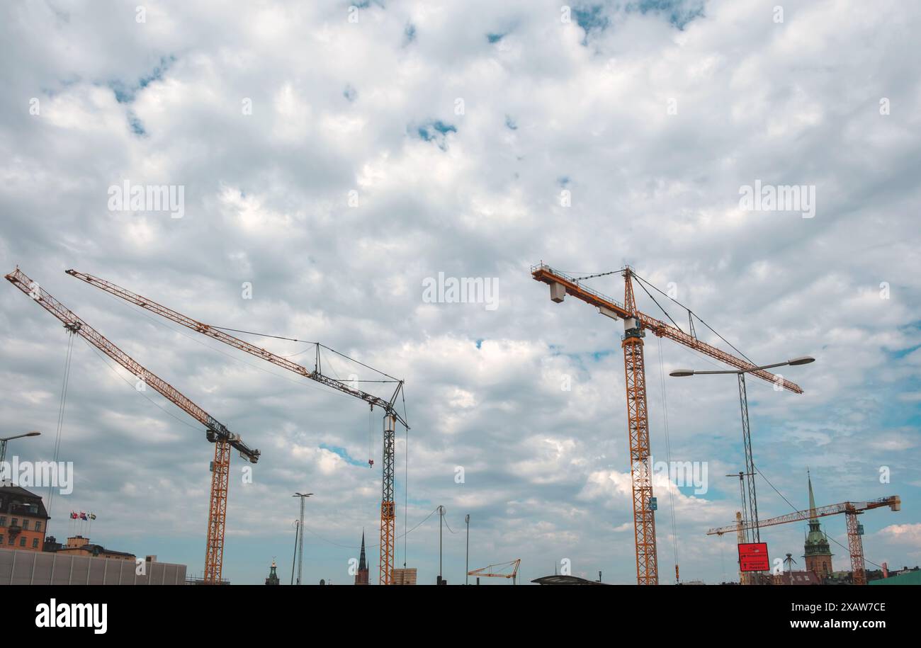 Under construction concept. Tower crane at building site on cloudy sky ...