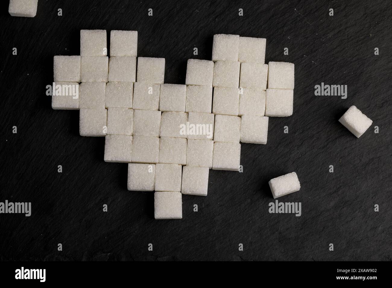 white square sugar on a black background , lump sugar in the shape of a ...