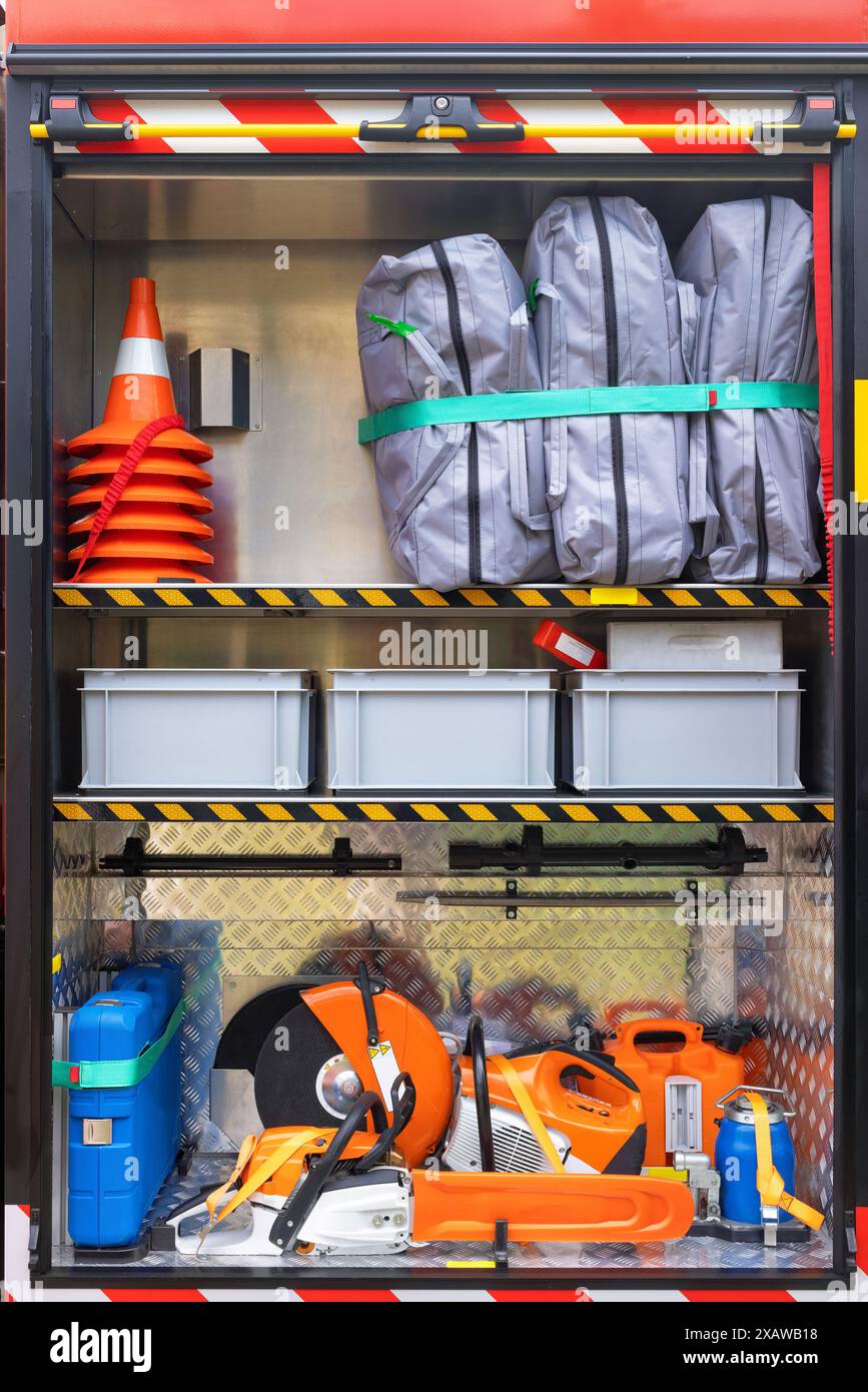 The cargo compartment of a loaded fire truck contains a chainsaw ...