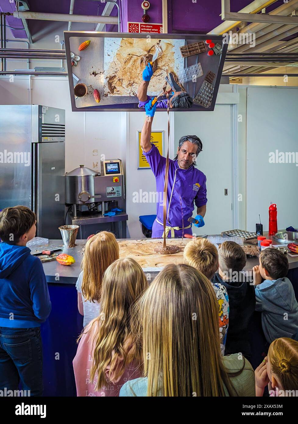 Bournville, UK. June 9, 2024. Children enjoy a chocolate tempering demonstration at Cadbury ...