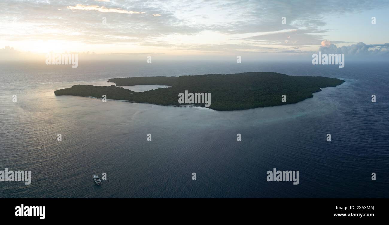 Calm water bathes the scenic coast of a remote island in the Forgotten Islands of eastern Indonesia. This region harbors high marine biodiversity. Stock Photo