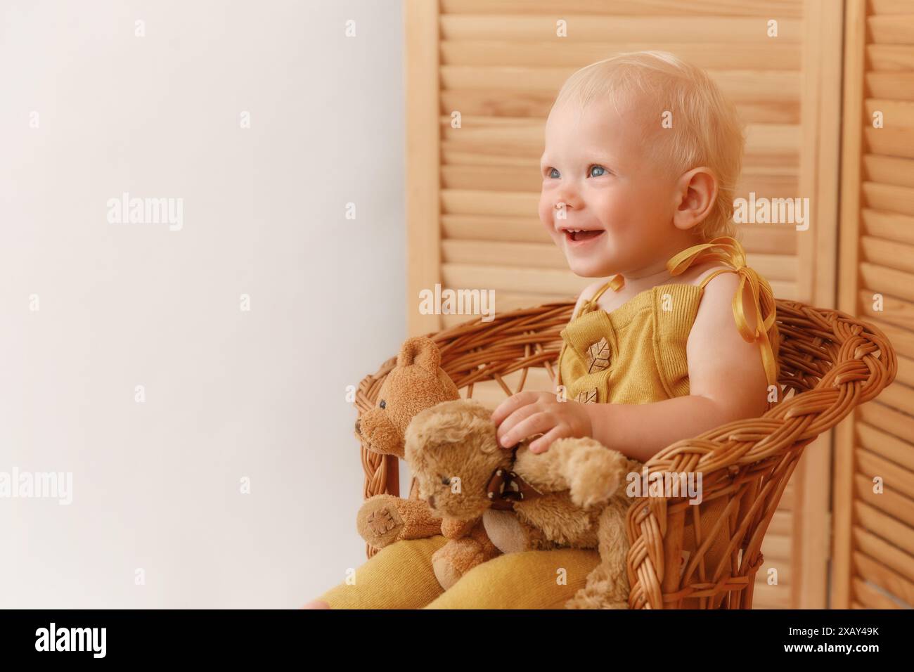 Boy sitting on armchair and holding a teddy bear Stock Photo - Alamy