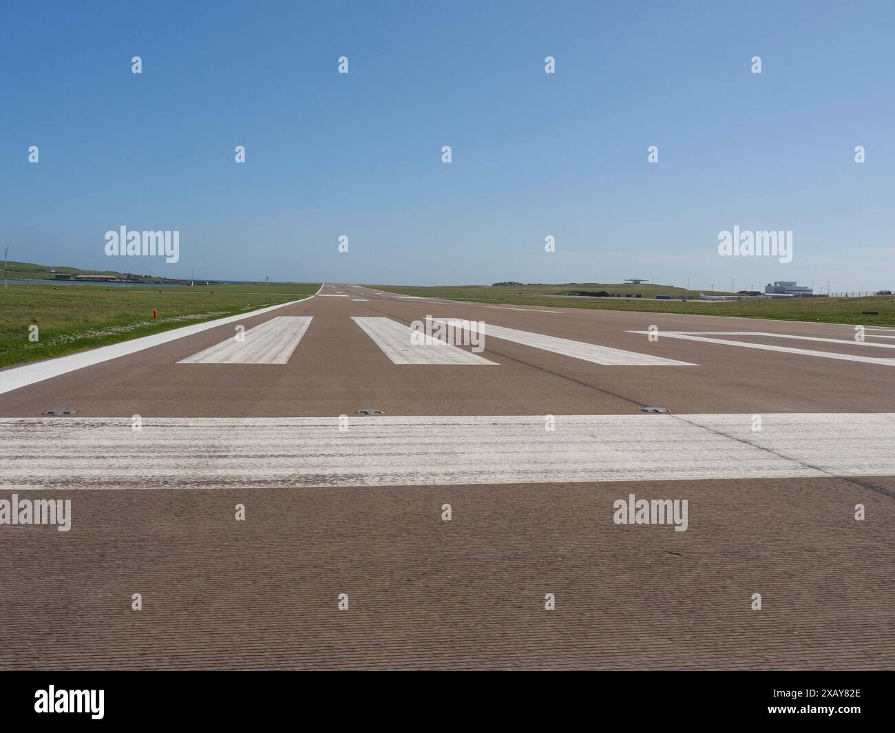 Airport runway with clear, sunny sky and horizon in the background ...