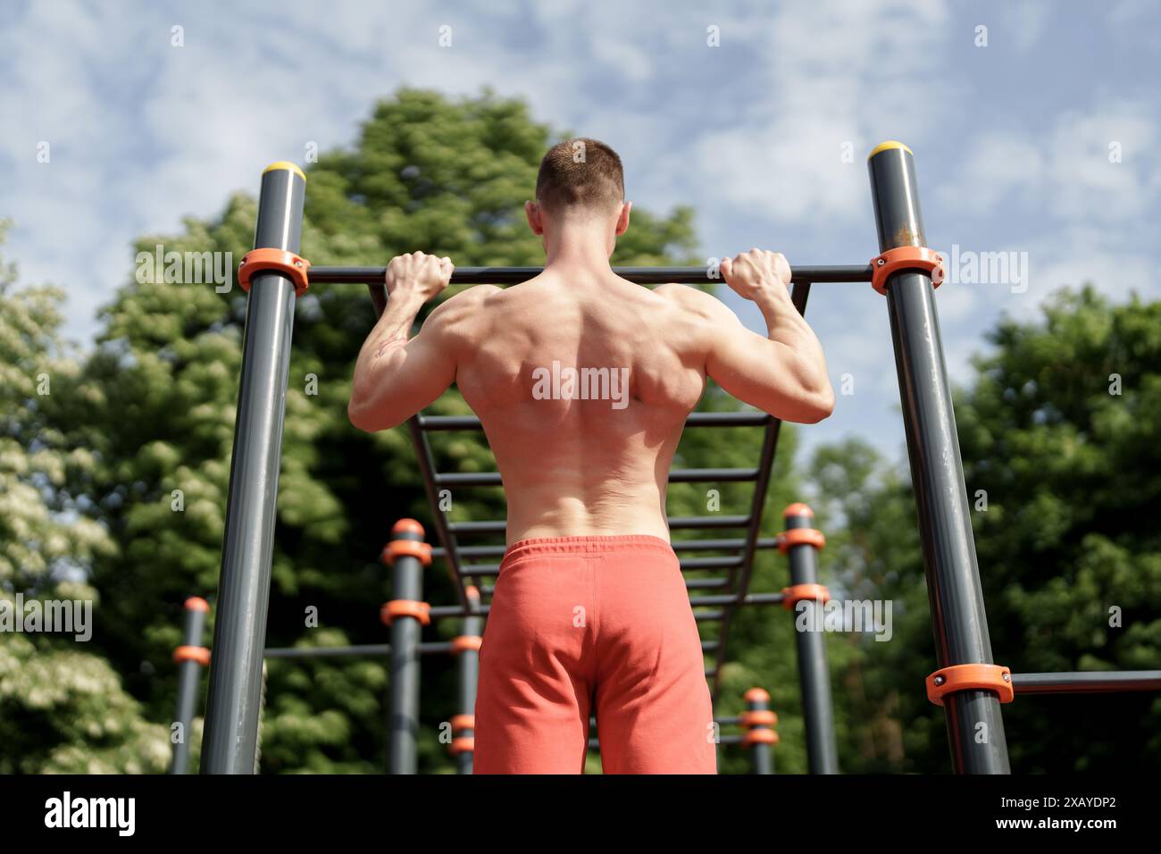 Muscular man doing pull-ups at an outdoor gym Stock Photo - Alamy