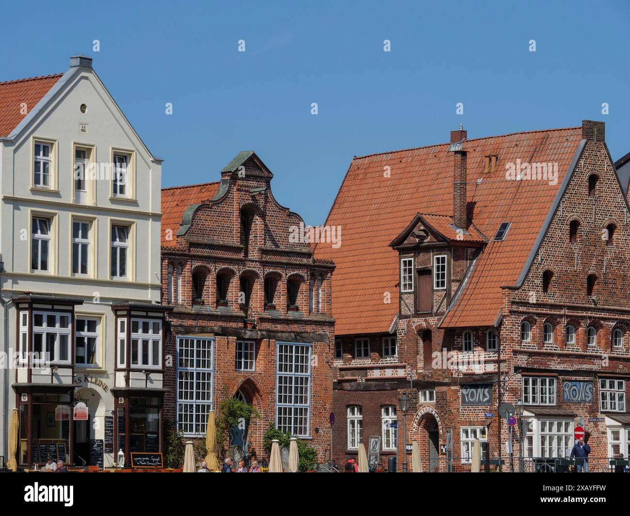 Scene on the canal with houses of different sizes and shapes, lively city life, restaurant business, lueneburg, germany Stock Photo