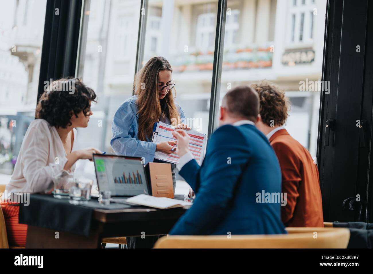 Business team analyzing charts and graphs in a modern coffee bar ...
