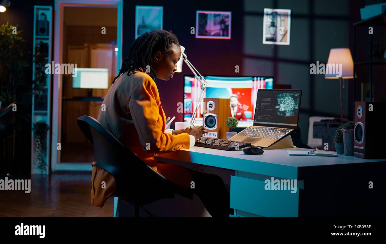 African american girl uses artificial intelligence software for machine learning and cloud computing, terminal window programming language. IT student studying deep learning AI hardware. Camera B. Stock Photo