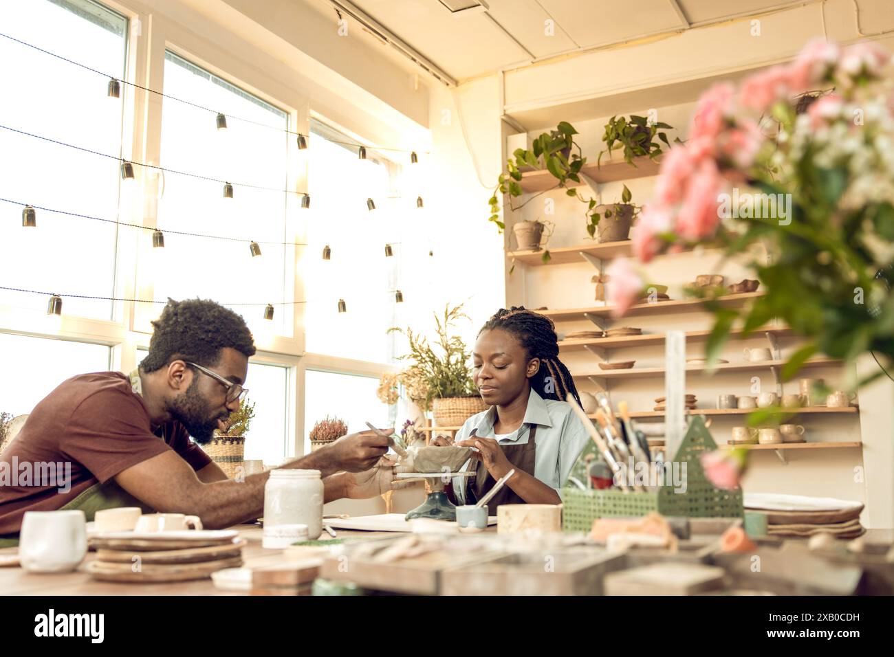 Two people working with pottery and looking involved Stock Photo - Alamy