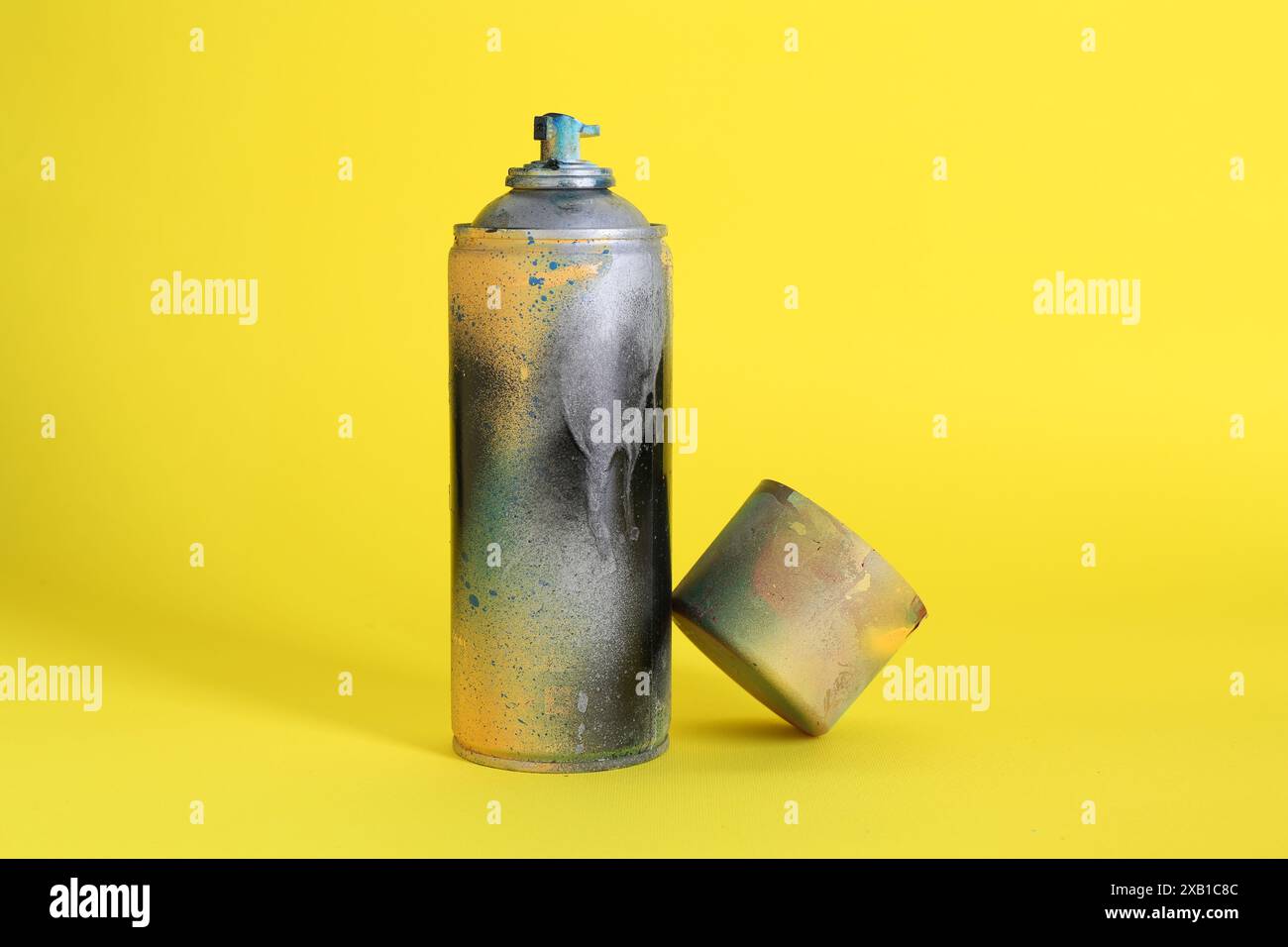 One spray paint can with cap on yellow background Stock Photo