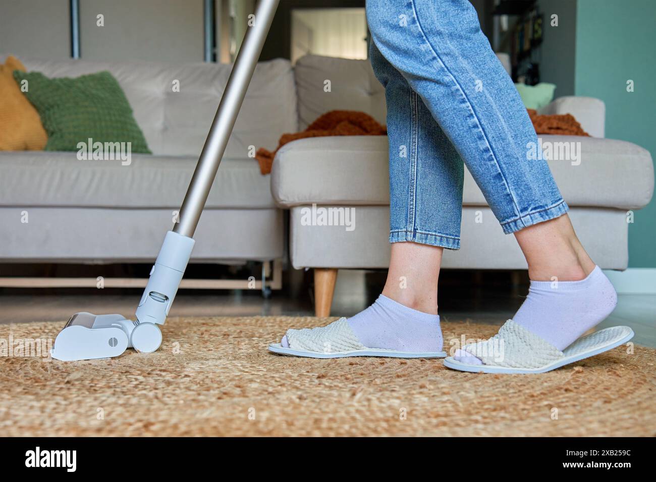 Woman Is Vacuuming Floor Of Modern Apartment Living Room Using woman-is-vacuuming-floor-of-modern-apartment-living-room-using