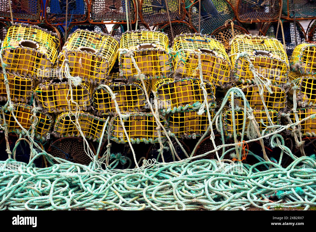 Piles of yellow lobster pots and green ropes used in commercial fishing ...