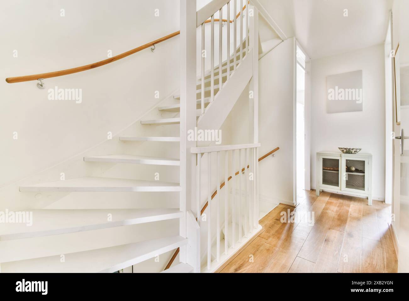 A contemporary interior showcasing a white staircase with wooden ...