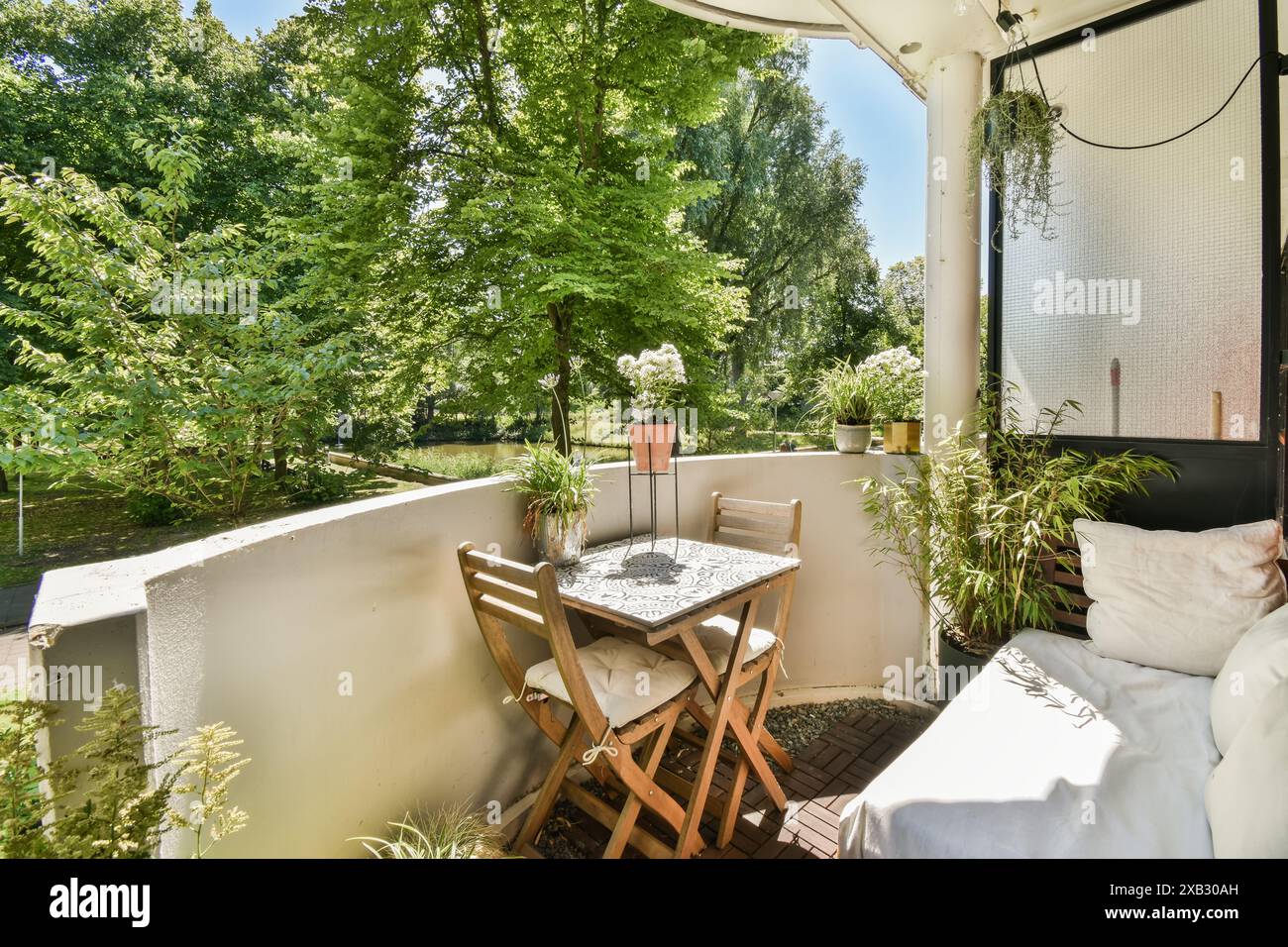 Cozy balcony with a wooden table and chairs set amidst lush greenery ...