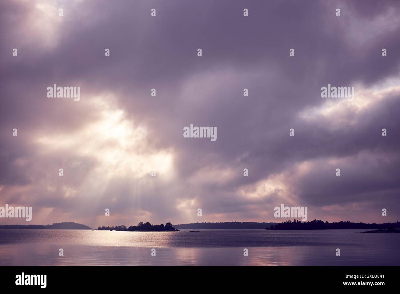 Lake under cloudy sky with sunlight Stock Photo - Alamy
