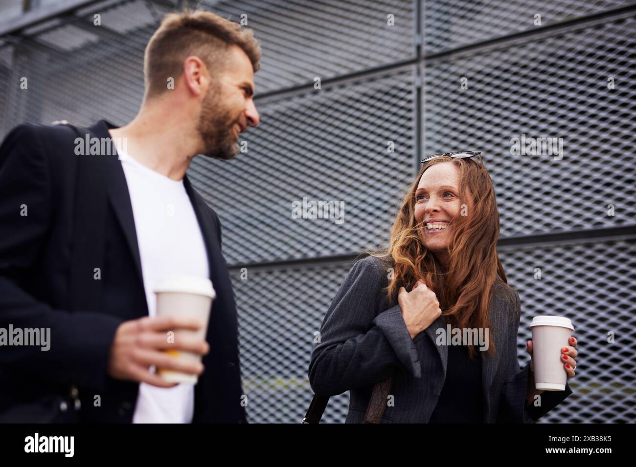 Happy male and female colleagues with disposable cups Stock Photo - Alamy