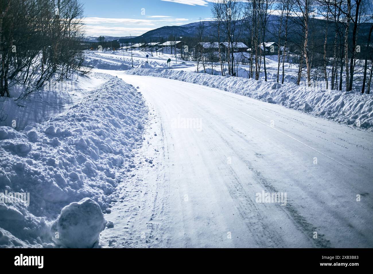 Snow covered empty road amidst trees Stock Photo - Alamy