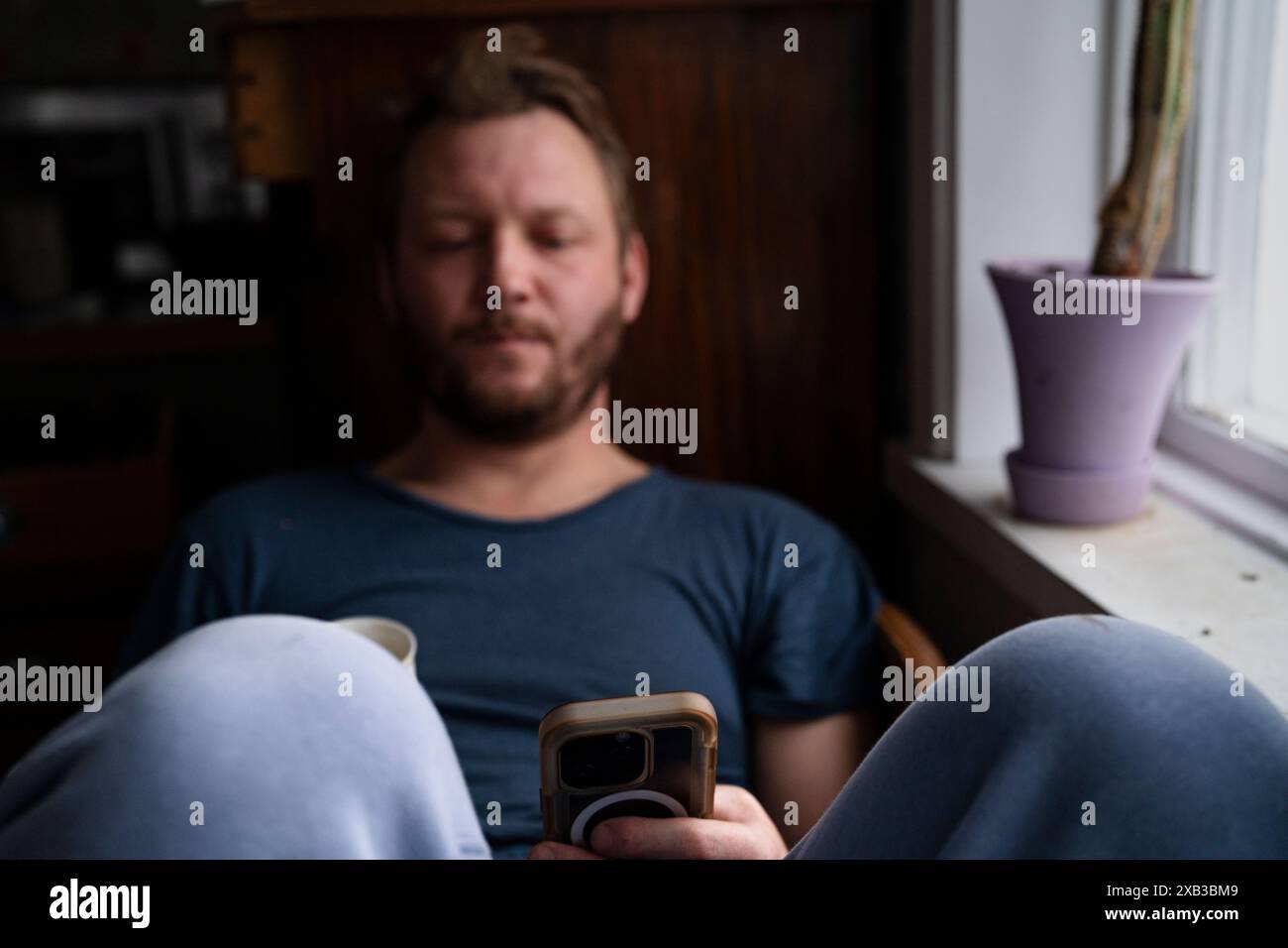 Man using smart phone while sitting at home Stock Photo