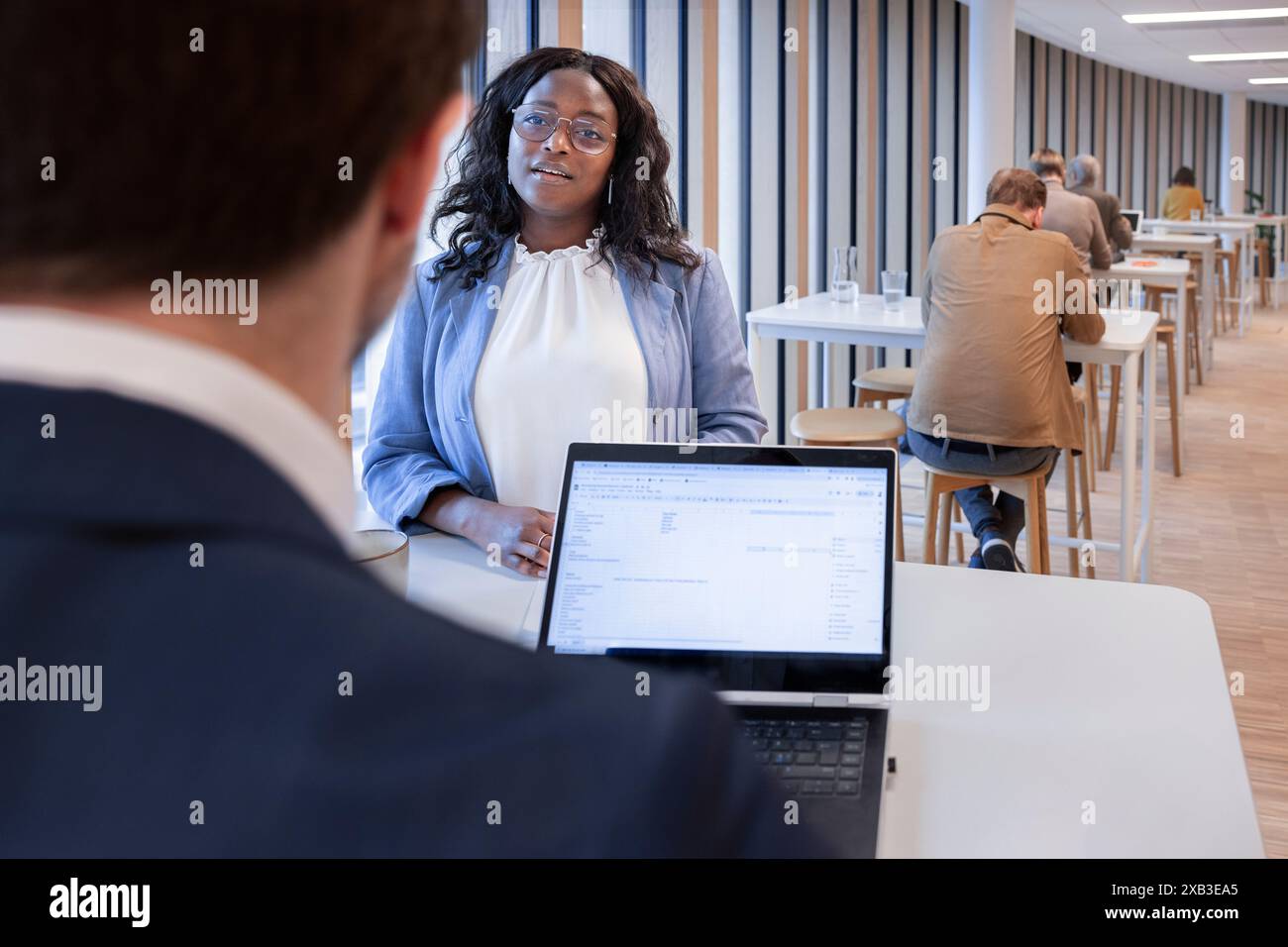Businesswoman discussing with businessman at table in office cafeteria Stock Photo