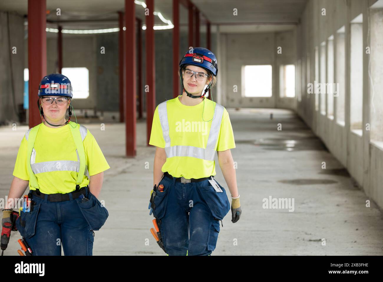 Confident female engineers discussing while walking at construction site Stock Photo