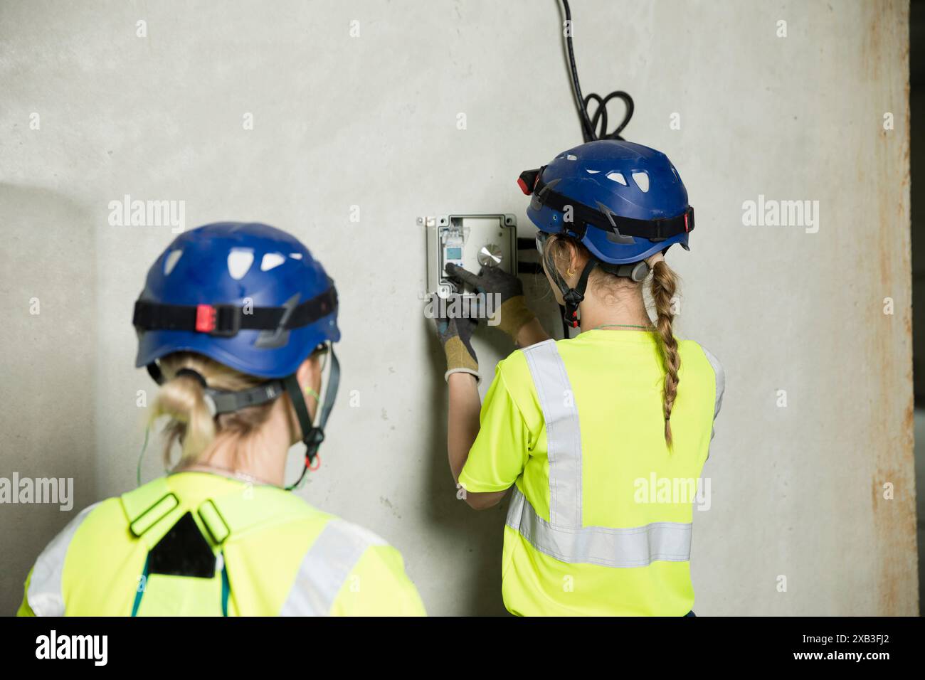 Female engineers working on electrical equipment at construction site Stock Photo