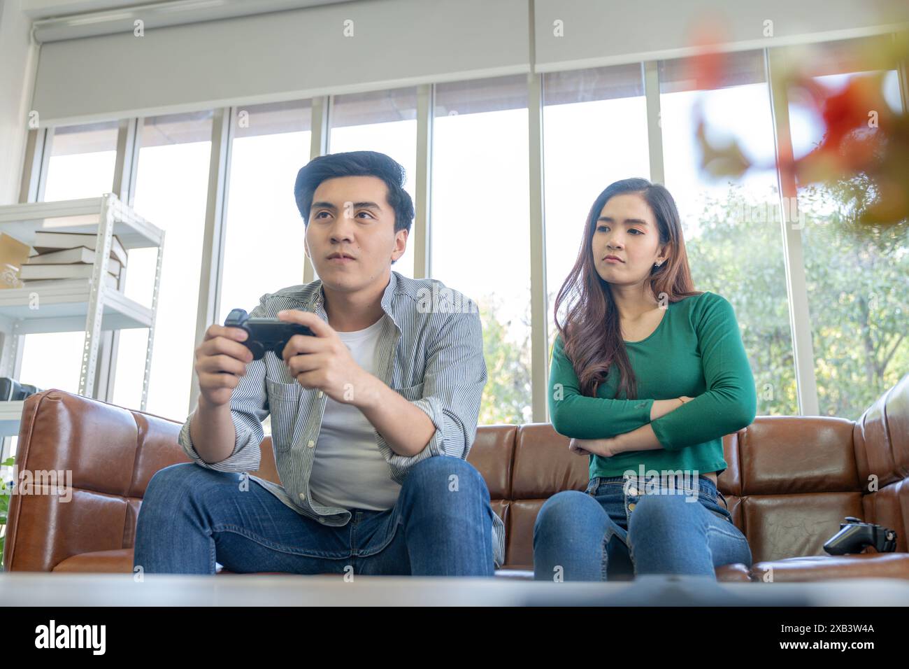 The young man plays games, ignoring his girlfriend Stock Photo - Alamy