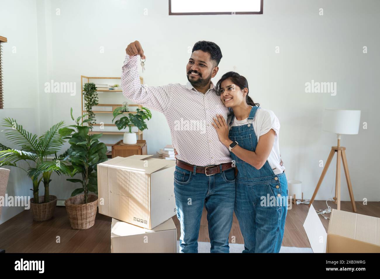 Happy Indian Couple Moving into New Home, Holding Keys, Surrounded by ...