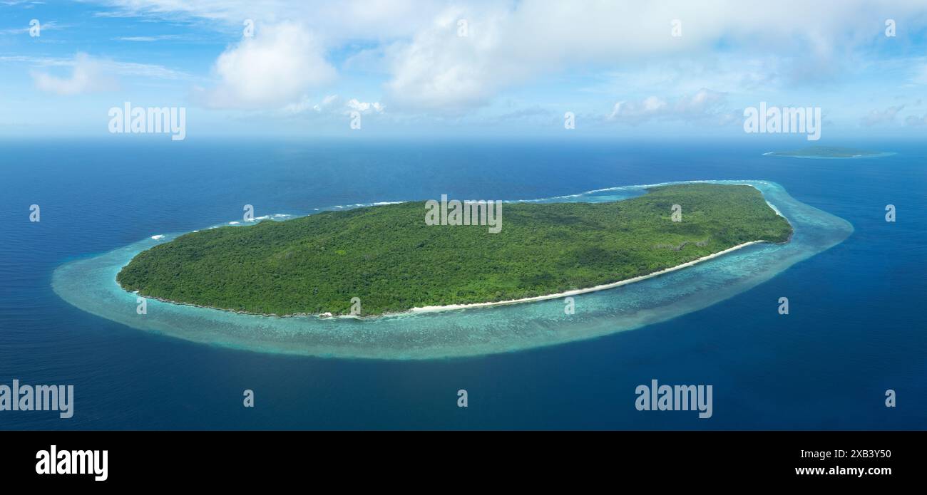 Calm water bathes the scenic coast of a remote island in the Forgotten Islands of eastern Indonesia. This region harbors high marine biodiversity. Stock Photo