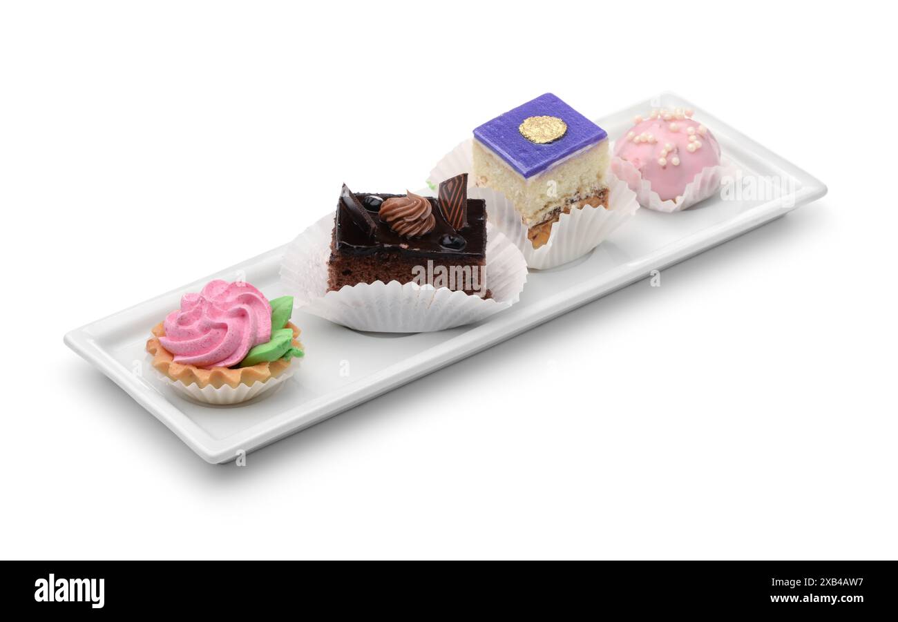 Set of different mini cakes on rectangular plate isolated on white Stock Photo