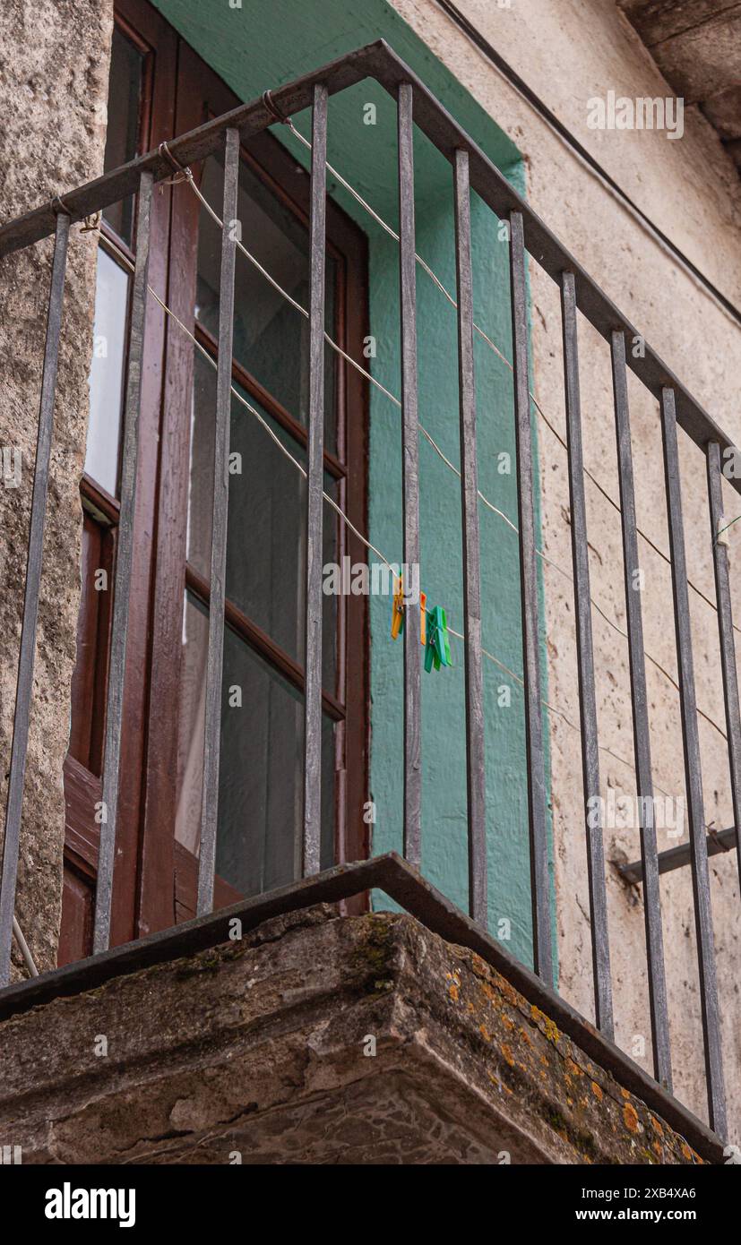 A bottom side view of an antique black iron balcony with a wood and ...