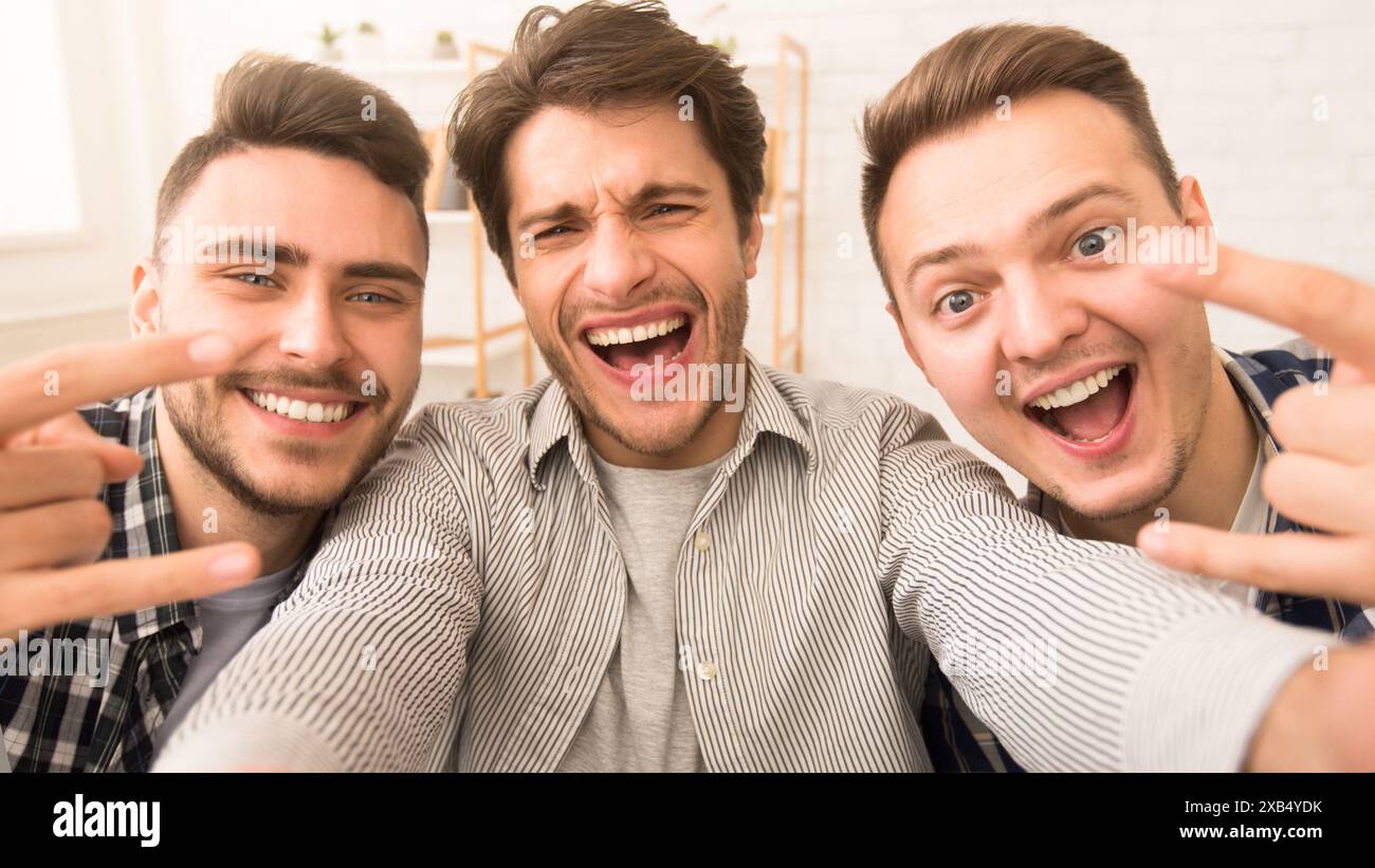 Three happy young men smiling at the camera Stock Photo
