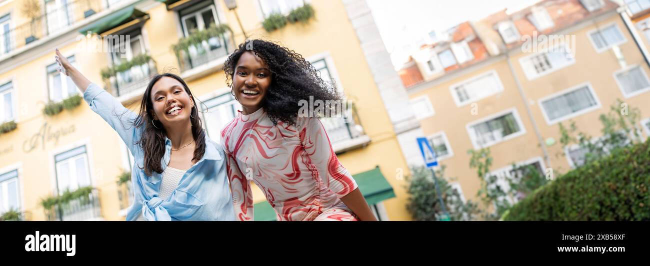 Two Happy Multiethnic Girlfriends Laughing, Having Fun While Posing Outdoors Stock Photo