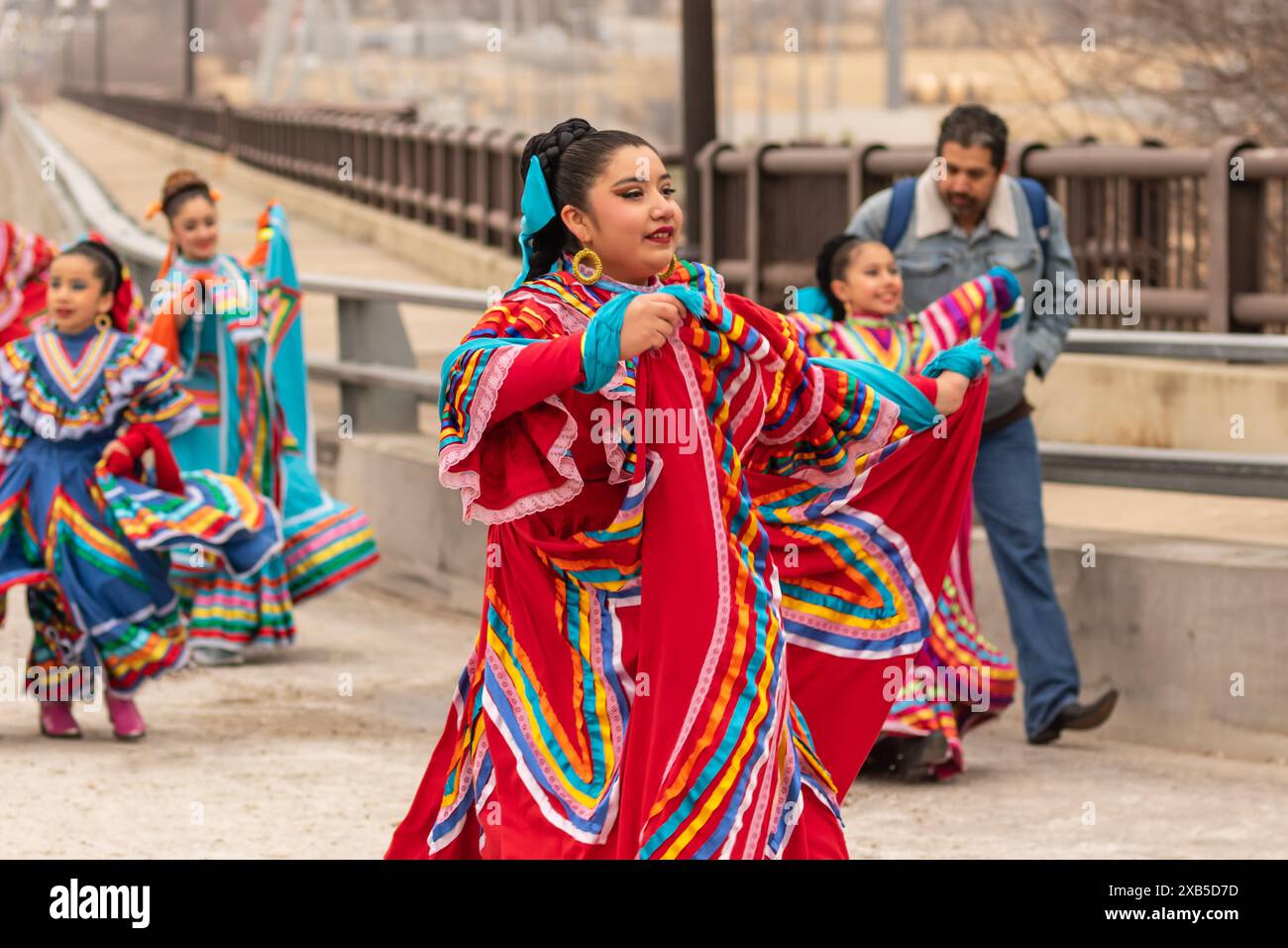 Beautiful Hispanic dancers in full costumes march and dance in the Fort Worth, Texas all western parade. Stock Photo