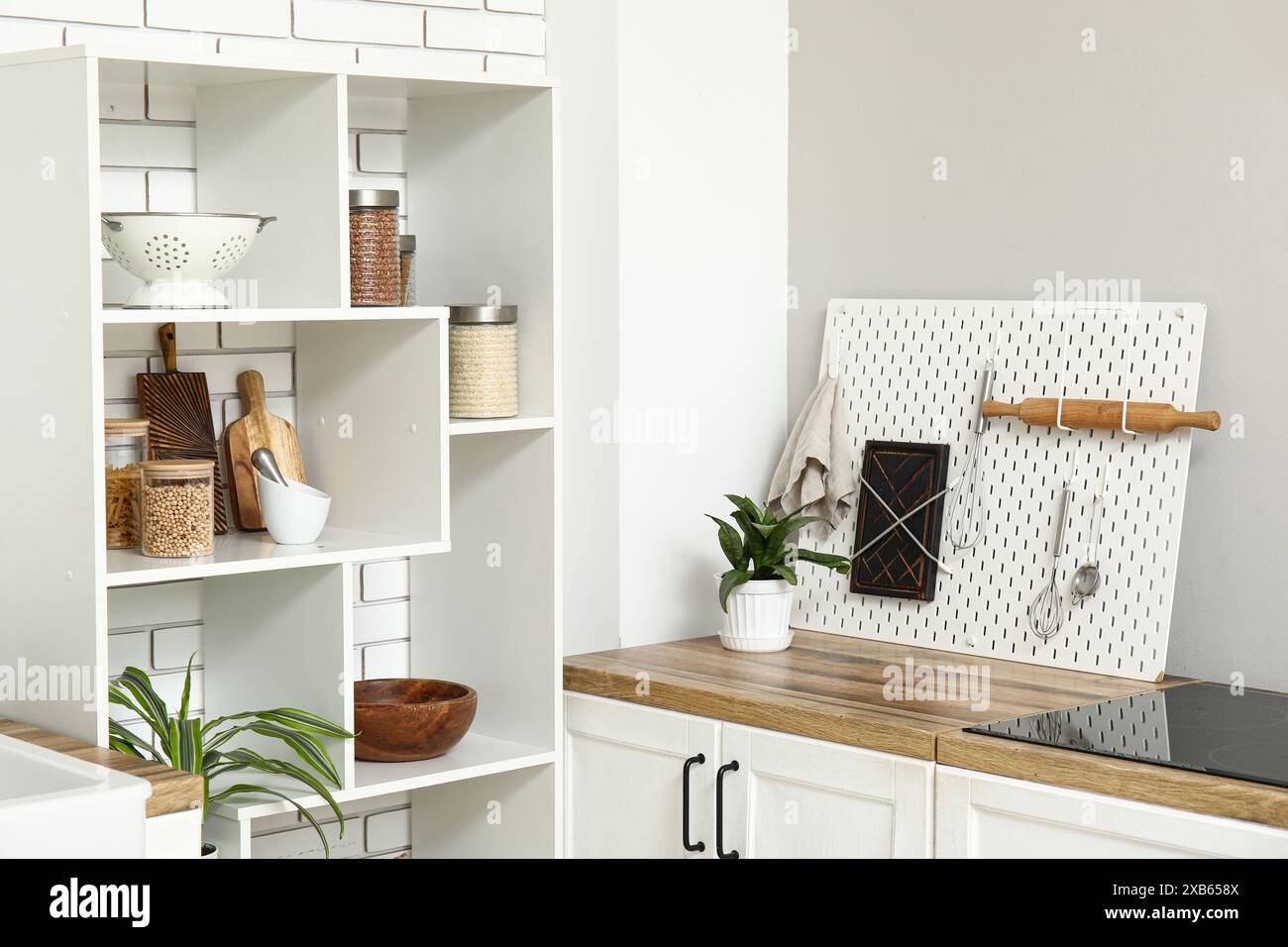 Stylish light kitchen with pegboard and kitchenware Stock Photo - Alamy