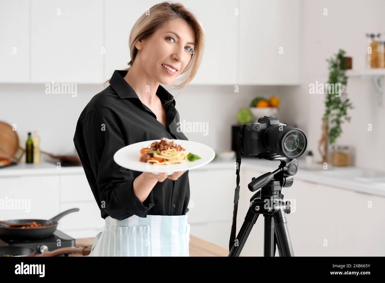 Food Blogger Photo Female food blogger with tasty pasta and camera in kitchen Stock Photo ...
