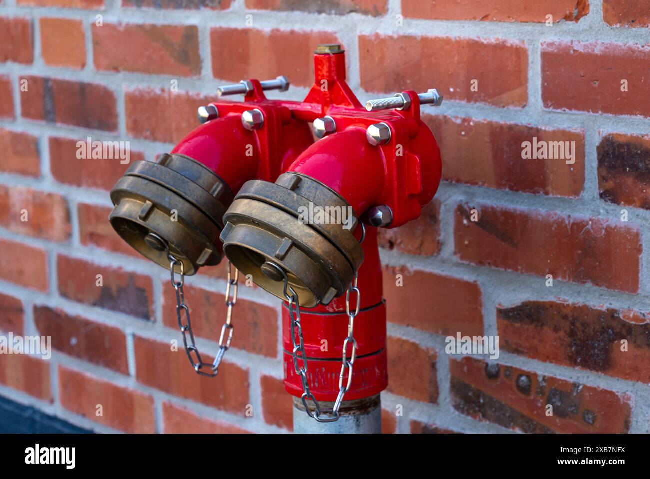 Bright red fire hydrants on a brick wall. Close up Stock Photo - Alamy