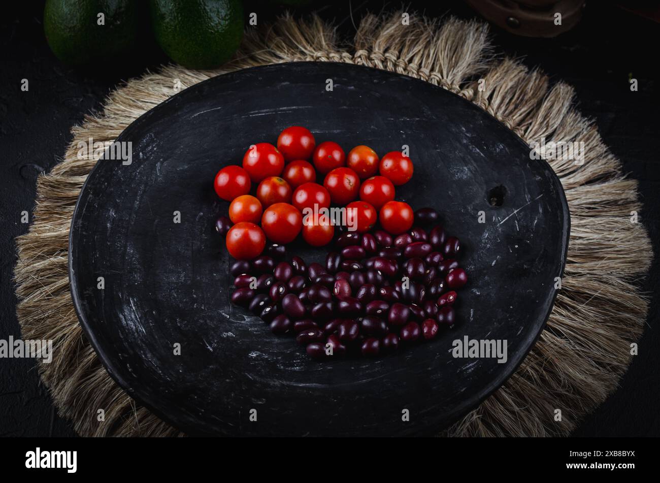 Tomatoes on plate outdoors with grass background Stock Photo