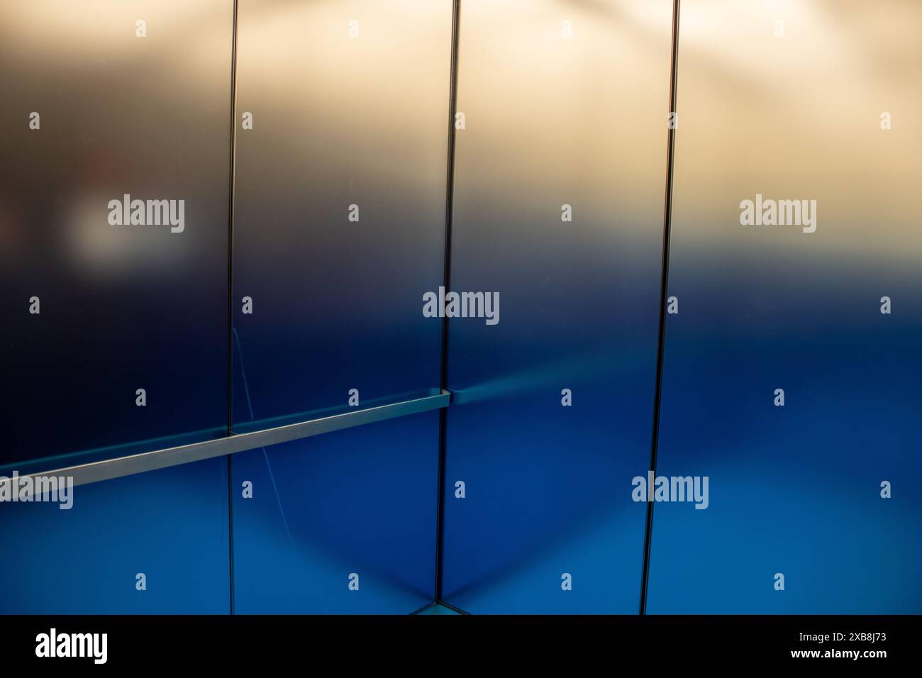 An illuminated metallic blue and silver wall Stock Photo