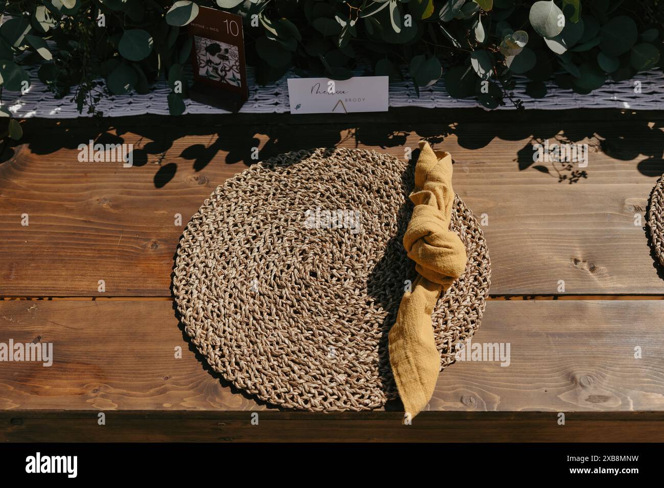 A setup of placemats on a wooden outdoor table Stock Photo