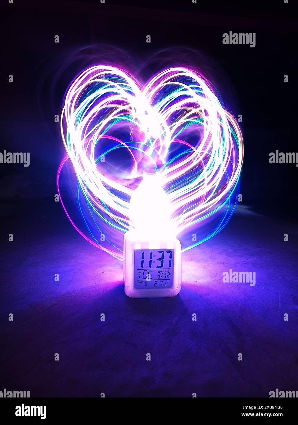 A glowing heart shape created by light painting on a screen Stock Photo